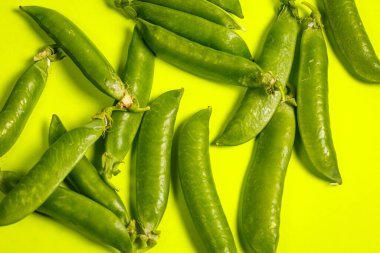 Yeşil bir zemin üzerinde olgun yeşil bezelyeler