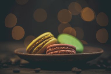 Tahta bir sehpanın üzerinde kahve ile nefis kurabiyeler ve güzel bir bokeh.