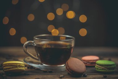 Tahta bir sehpanın üzerinde kahve ile nefis kurabiyeler ve güzel bir bokeh.