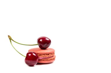 Beyaz arka planda lezzetli kurabiyeler ve kırmızı kirazlar.