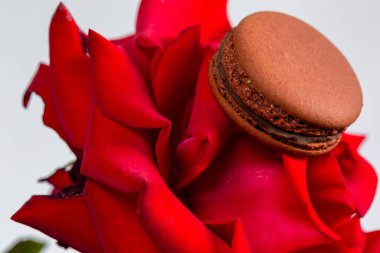 Lezzetli kurabiyeler ve beyaz arka planda kırmızı gül.