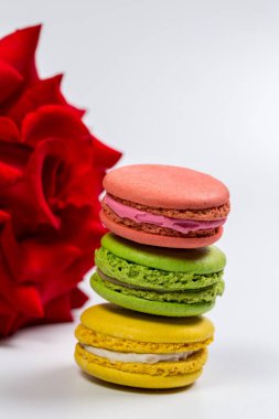 Lezzetli kurabiyeler ve beyaz arka planda kırmızı gül.