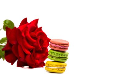 Lezzetli kurabiyeler ve beyaz arka planda kırmızı gül.