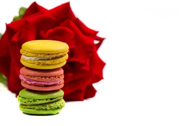 Lezzetli kurabiyeler ve beyaz arka planda kırmızı gül.