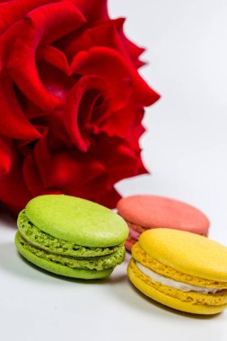 Lezzetli kurabiyeler ve beyaz arka planda kırmızı gül.