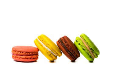 Beyaz arka planda farklı renklerde lezzetli kurabiyeler.