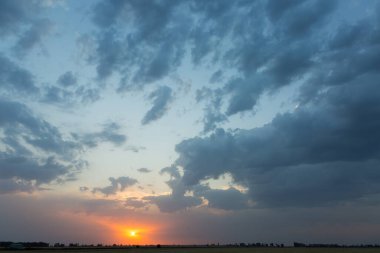 Yağmurdan sonra bulutlarla dramatik turuncu gün batımı