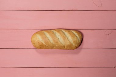 Pembe arka planda taze bir somun glütensiz ekmek.
