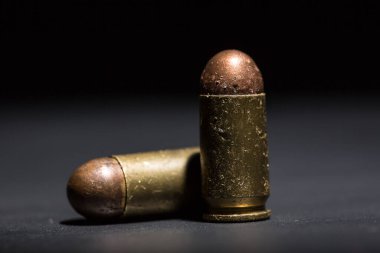 9mm 'lik tabanca mermisi ve siyah arka planda nefsi müdafaa.