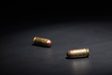 9mm 'lik tabanca mermisi ve siyah arka planda nefsi müdafaa.