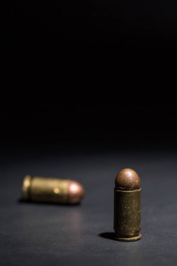 9mm 'lik tabanca mermisi ve siyah arka planda nefsi müdafaa.