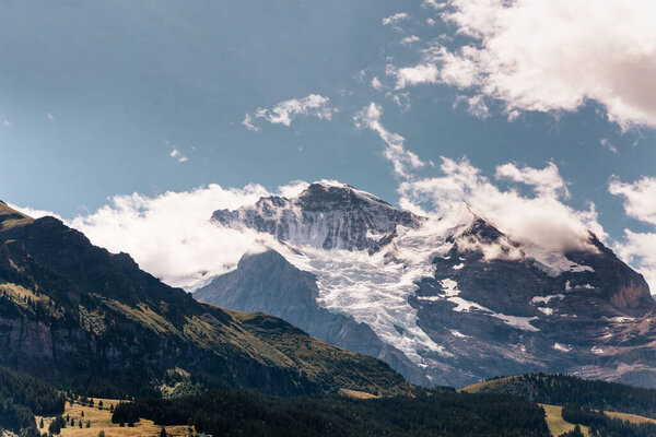 Scenic view on green mountings and sky in Lauterbrunnen Valley, Switzerland