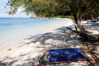 Tayland 'da tropikal plajda mavi okyanus, beyaz kum ve hamak