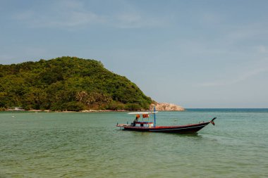 Tayland 'da mavi okyanuslu, beyaz kumlu ve tipik balıkçı tekneli tropik bir sahil.