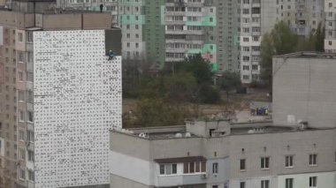 Yüksek irtifa iş. Adam kaplama, evi sıvama yüksek katlı inşaat üstünde çalışıyor. Yüksek katlı binaların duvarları ısınma. Yüksek katlı binaların duvarları ısınma. Yüksek irtifa eser bir yerleşim bölgesinde bulunmaktadır. Evler ısınma.