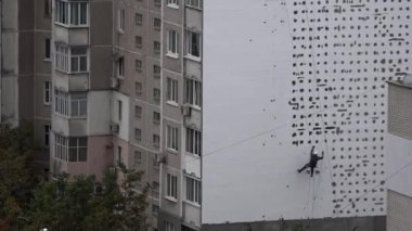 Yüksek irtifa eser bir yerleşim bölgesinde bulunmaktadır. Evler ısınma. Yüksek irtifa iş. Adam kaplama, evi sıvama yüksek katlı inşaat üstünde çalışıyor. Yüksek katlı binaların duvarları ısınma. Yüksek katlı binaların duvarları ısınma.