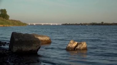 Dinyeper River.The dalgalar ağzında sonbahar bankalar kıyıda rulo. Nehir akışı. Nehir ağzı. Dinyeper River.River akışı ağzında manzara. Taşlar nehrin yanında ön planda.