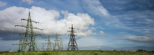 Güçlü elektrik dişli hatları. Güç hatları ve bulutlar ile gökyüzü. Alanlar üzerinde teller. Elektrik enerjisi endüstrisi ve doğa konsepti. Yüksek voltaj güç hatları. Alan ve hava hatları, karanlığı siluetleri. Bozkır güç istasyonu.