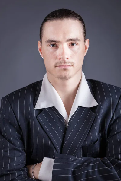 Young male confident male posing in gangster style suite