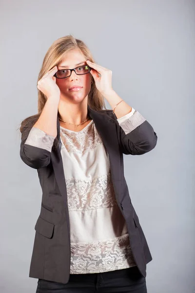 Portrait of serious woman in jacket touching head by fingers — Stock Photo, Image