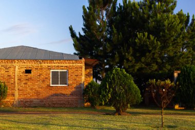 yeşil ön planda yaz güneşli gün ile gri çatı ile küçük taş ev