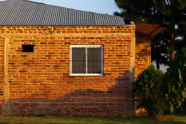 yeşil ön planda yaz güneşli gün ile gri çatı ile küçük taş ev