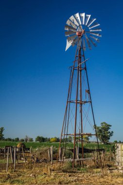 Bir çiftlikte mavi gökyüzü üzerinde eski yel değirmeni