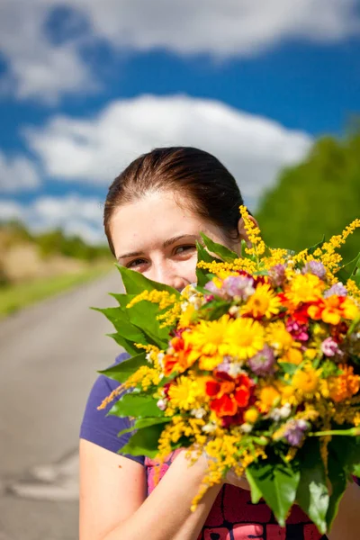草原の花の臭いがする若いかわいい幸せな女 — ストック写真