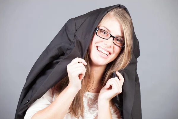 Young beautiful woman smiling, covered her head with jacket — Stock Photo, Image