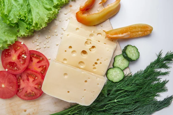 Arrangement mit Tomaten, Pfeffer, Käse und Salat beim Schneiden — Stockfoto