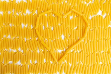İtalyan Penne Rigate Makarna Makarna kalp şeklinde arka plan üzerinde