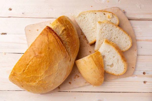 Wit gesneden brood op de snijplank op houten achtergrond. — Stockfoto