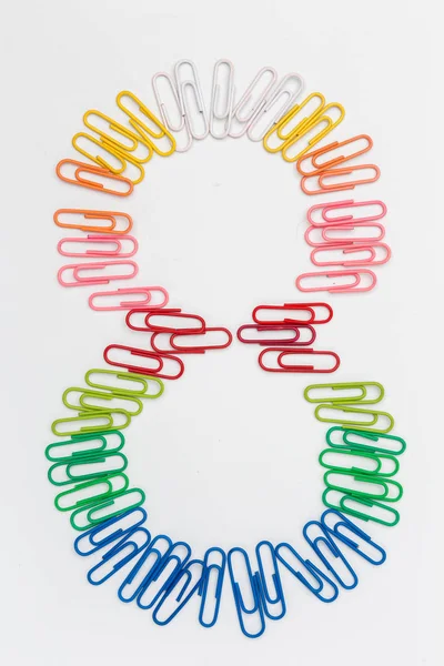 Número oito feito de clipes de papel arco-íris de cor em branco — Fotografia de Stock