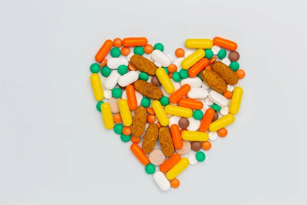 Tabletki i kapsułki inny kolor kształt serca — Zdjęcie stockowe