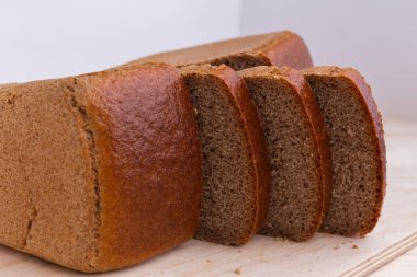 Ahşap masa üzerinde tuğla kahverengi Çavdar ekmek dilimleri