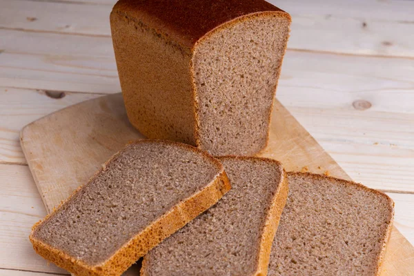 Ahşap masa üzerinde tuğla kahverengi Çavdar ekmek dilimleri — Stok fotoğraf