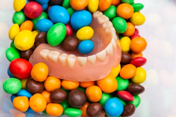 Montón de caramelos y prótesis dental en bombones de caramelos de color — Foto de Stock