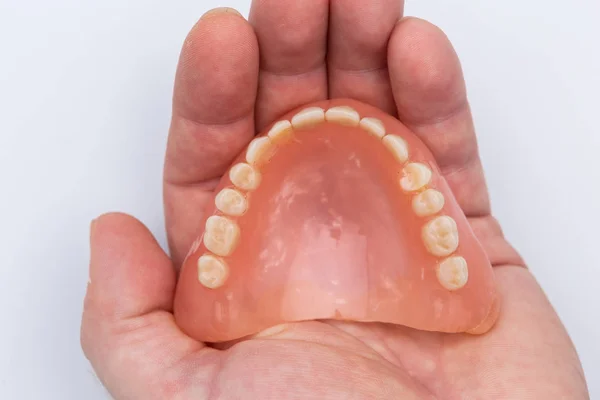 Denture in man hand closeup top view — Stock Photo, Image