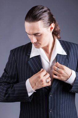 Genç erkek kendine güvenen erkek gangster tarzı süitte poz