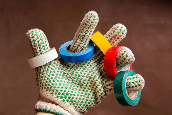 Color insulation tapes on fingers of hand in protective glove — Stock Photo, Image