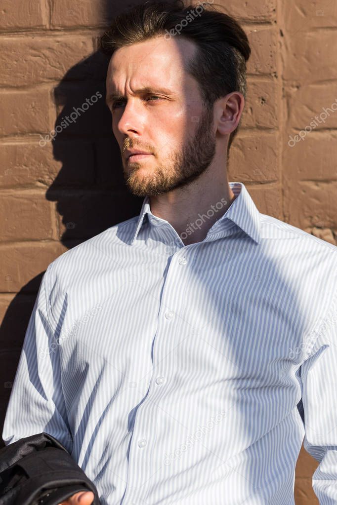 Half length portrait of young businessman with jacket in hands