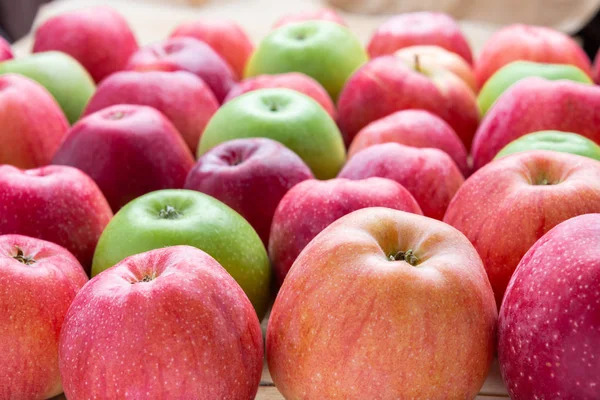 Cumulo di mele verdi e rosse non lavate mescolare su sfondo di legno — Foto Stock