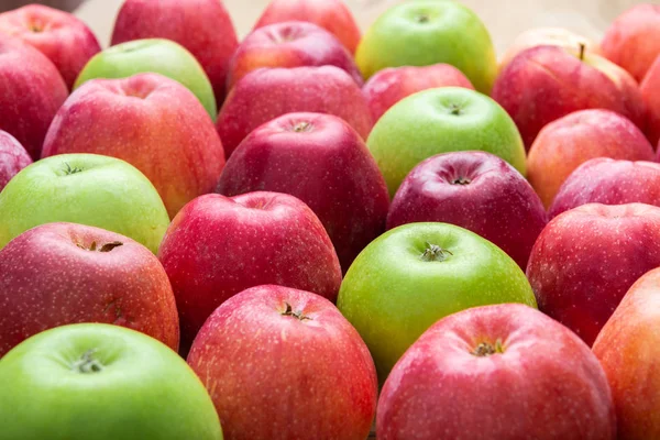 Куча немытых зеленых и красных яблок смешиваются на деревянном фоне — стоковое фото