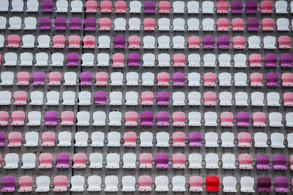 multi-colored rows of empty seats in football stadium