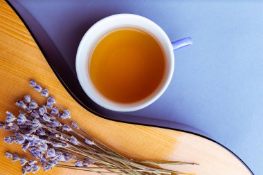 gitar desteyle kurutulmuş lavanta çiçekleri ve bardak bitkisel çay, portre, üstten görünüm.