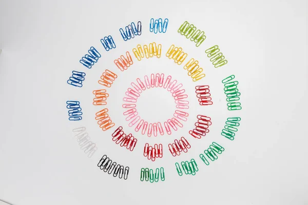 Figura espiral multicolorida de clipes de papel isolados em branco . — Fotografia de Stock