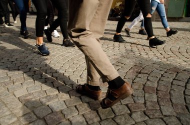 Foot traffic with different styles of shoes  on Stora Nygatan, Gamla Stan, Stockholm clipart