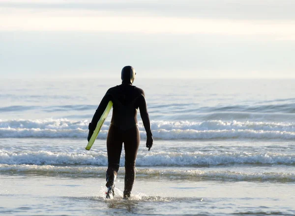 Surfboarder entra en el agua cerca del parque estatal Westport Lighthouse —  Fotos de Stock