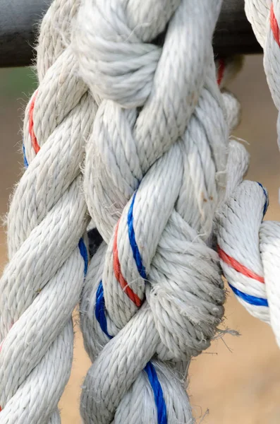 Corda colorida grossa em nós com fios azuis e lidos — Fotografia de Stock