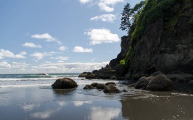 Bulutlar ve kayalar, alçak gelgit sırasında Ruby sahil sularında yansıyor, Olympic National Park, Washington